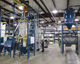A combination of flexible screw and pneumatic conveying meets process requirements, with five flexible screw conveyors transporting ingredients to a weigh-batching system, and vacuum pneumatic conveying taking weighed and mixed dry ingredients to wet blending. 
