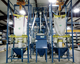 Bulk bag unloaders utilize a proprietary bag-spout interface that creates a high-integrity sealed connection to contain dust and prevent contamination of the product and plant environment. A manual bag dump station with dust collection (center) protects workers and prevents plant contamination. 